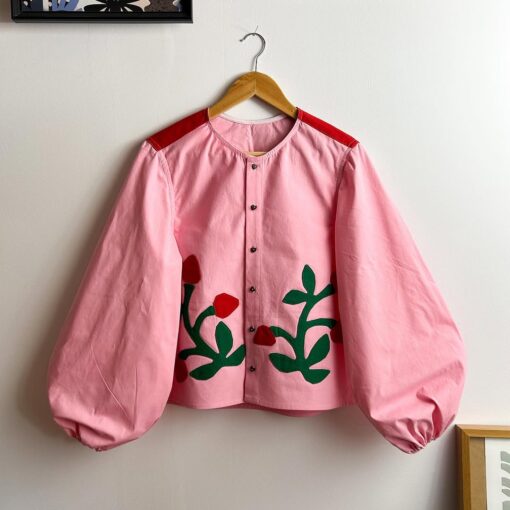 różowa koszula z motywem truskawek na przodzie i bufiastymi rękawami. wyprodukowana w polsce przez markę Alire studio